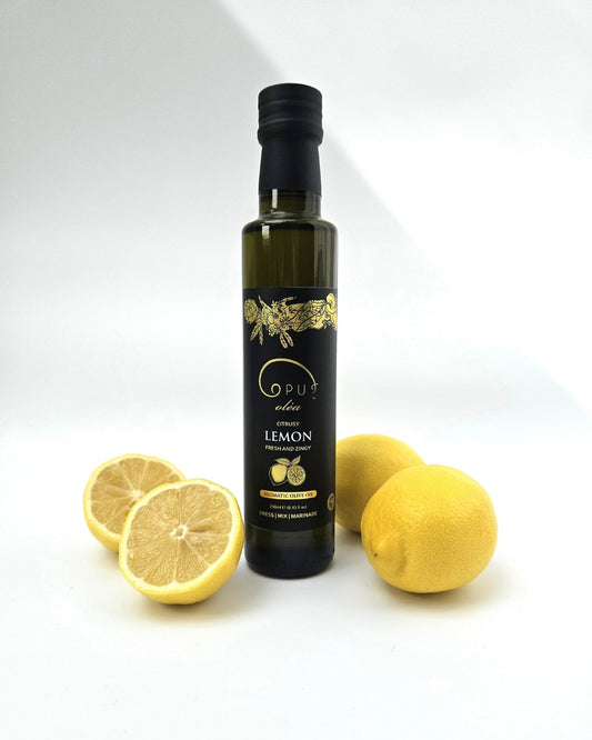 A bottle of Opus Lemon Olive Oil styled with fresh lemons. 