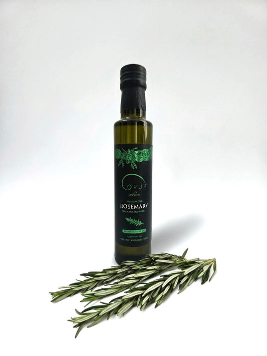 A bottle of Opus Rosemary Olive Oil styled with fresh sprigs of rosemary. 